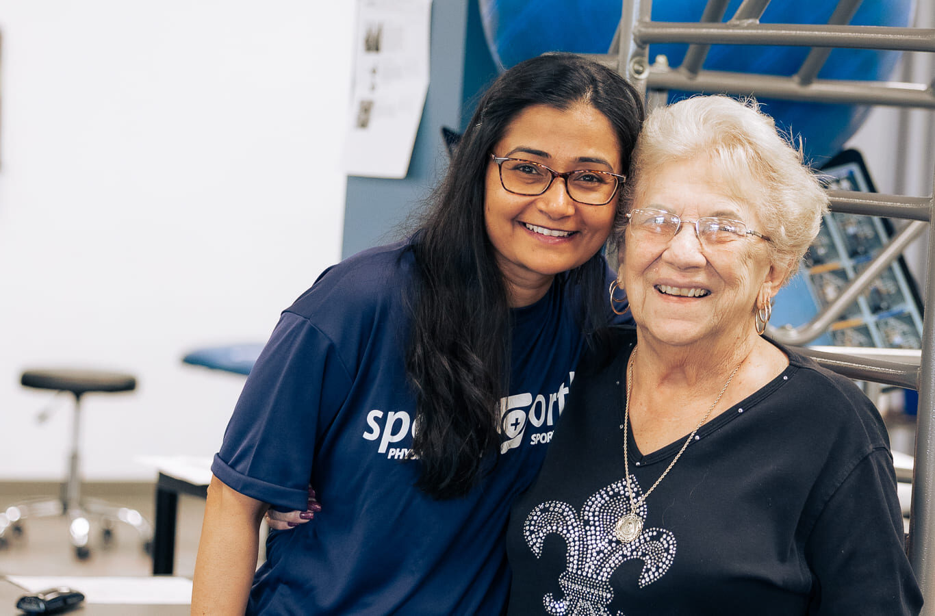 A Sports & Ortho therapist smiling with a patient at the clinic