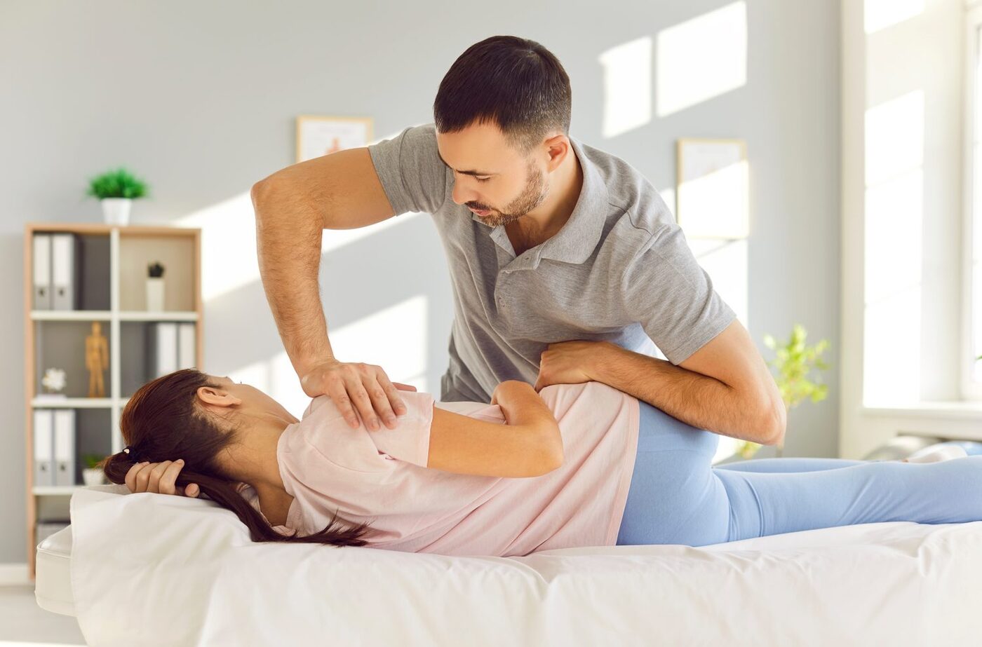 A physical therapist performing hands-on treatment on a patient's lower back