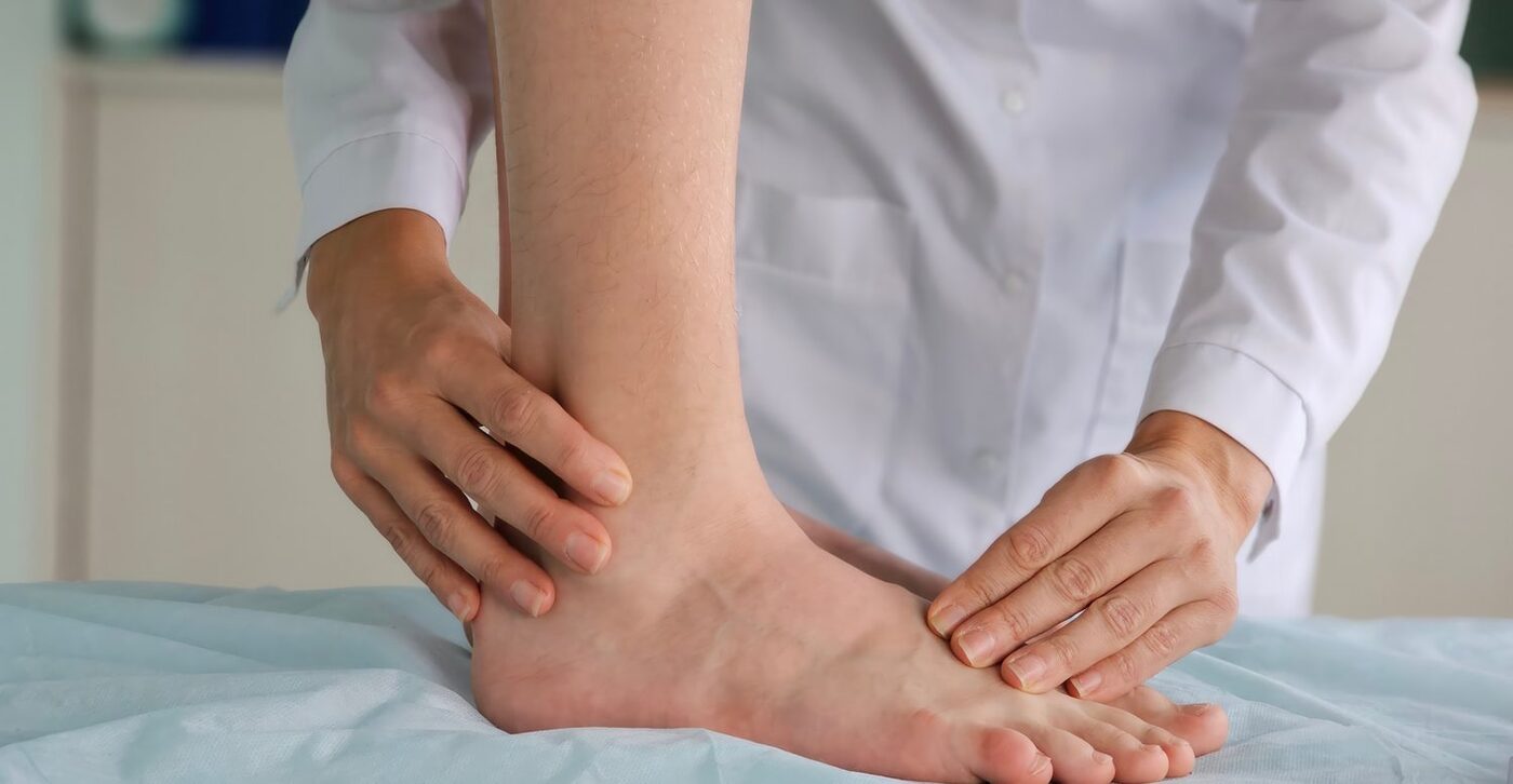 A therapist examining a patient's foot and ankle on a treatment table