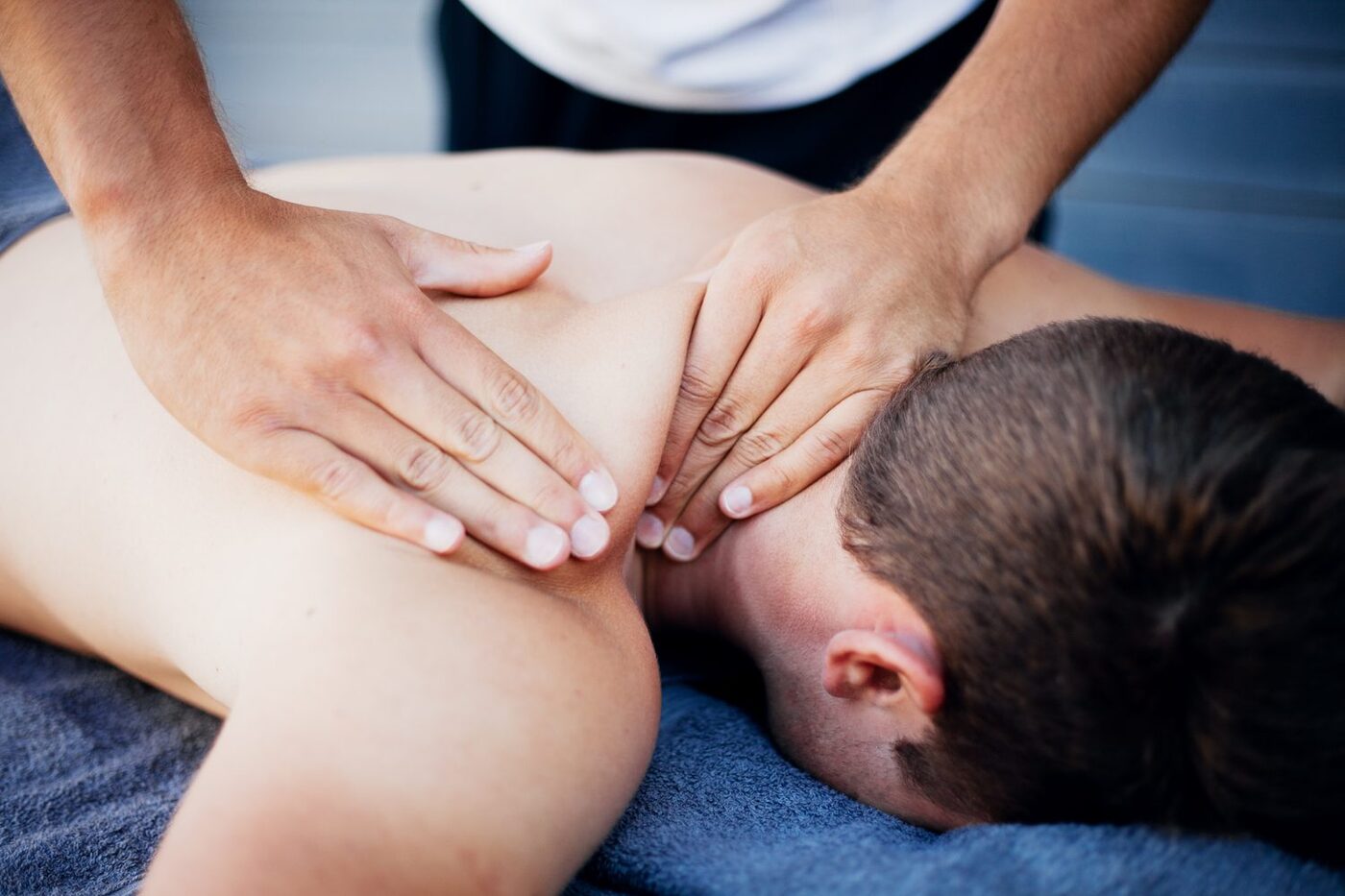 A Sports & Ortho therapist performing hands-on myofascial release on a patient's neck and shoulders