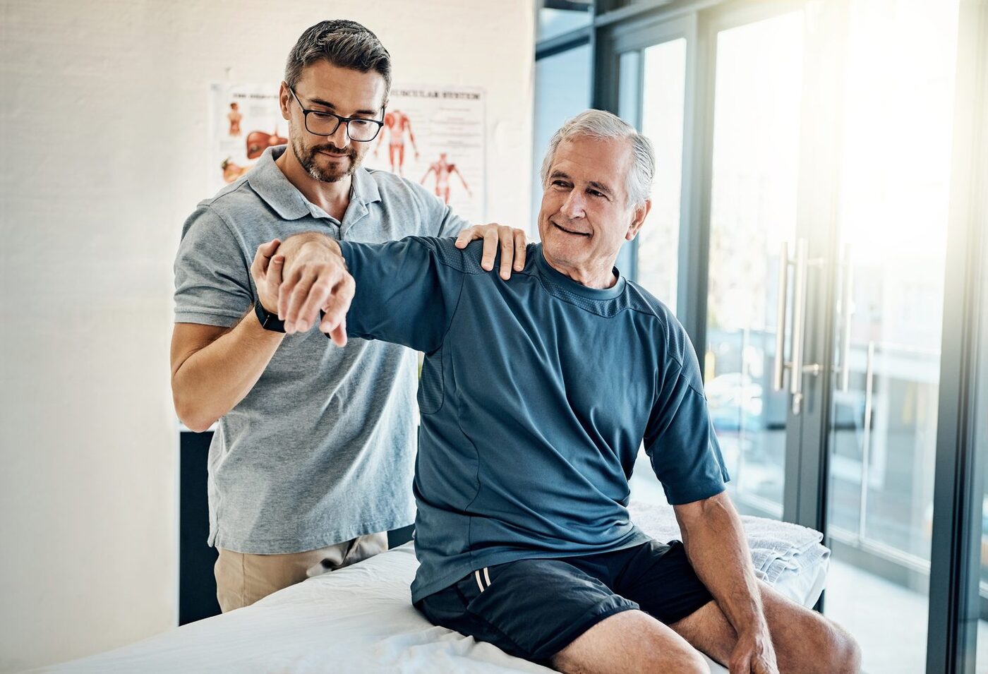 A therapist guiding an older patient through shoulder range of motion