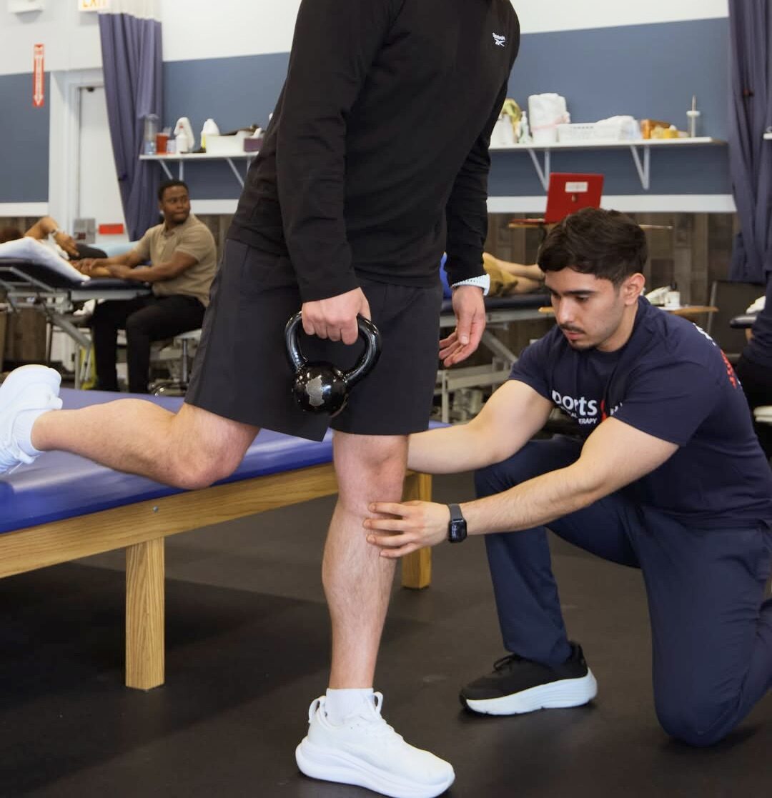 A Sports & Ortho therapist coaching a patient on workstation setup
