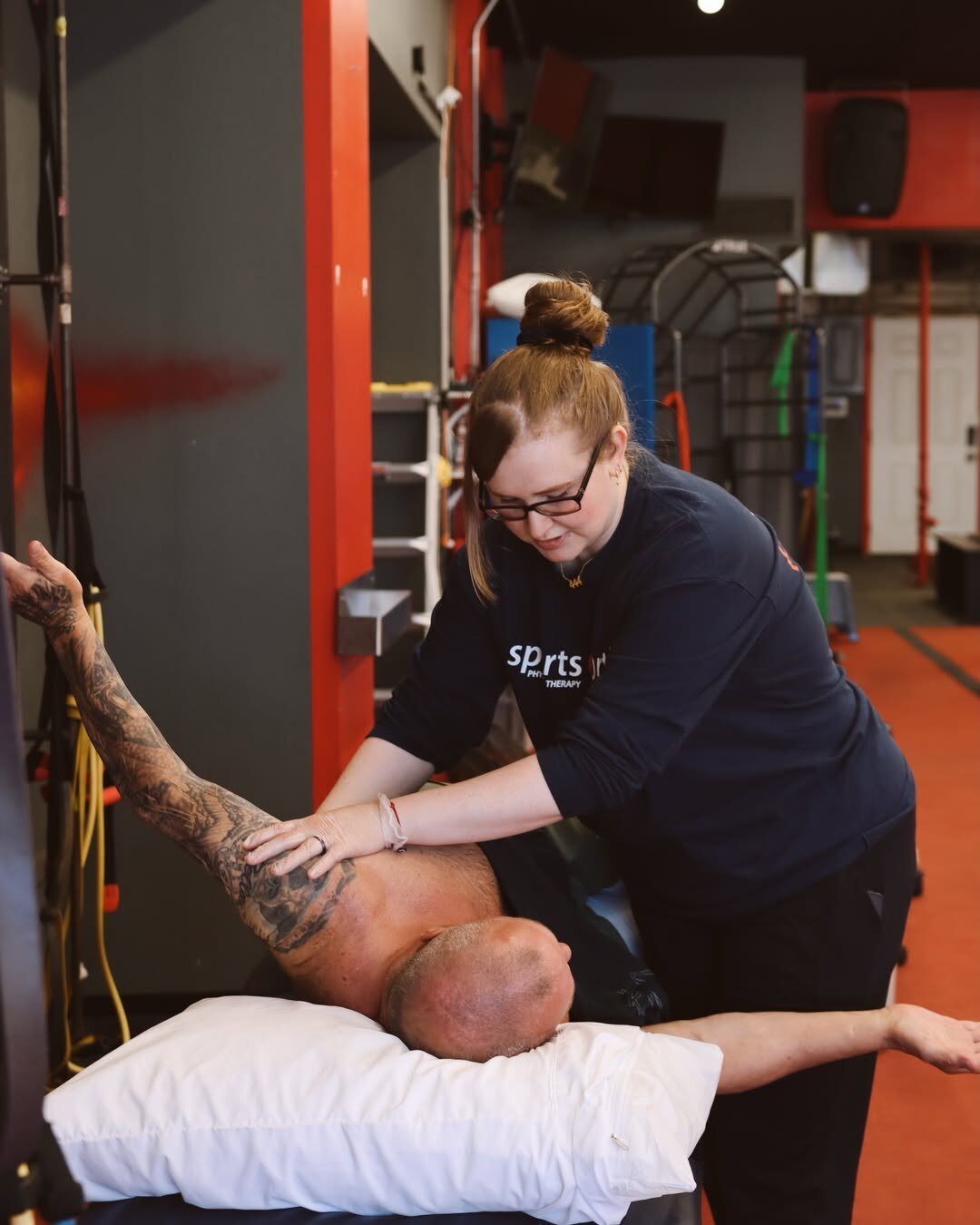 A Sports & Ortho physical therapist working hands-on with a patient at the treatment table