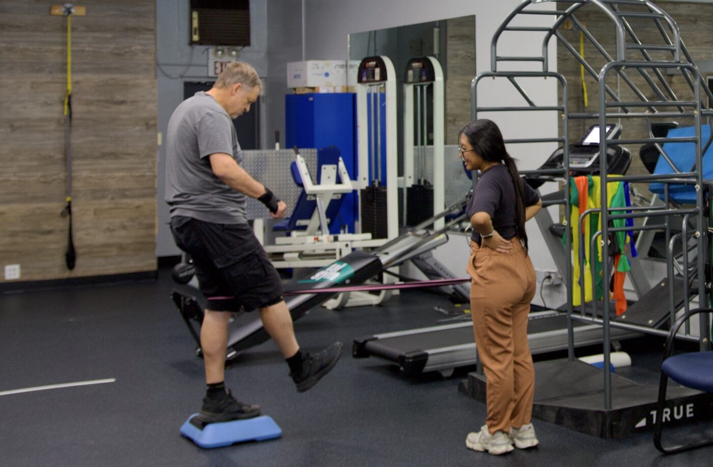A Sports & Ortho therapist guiding a patient through a balance exercise at the Lake Forest clinic
