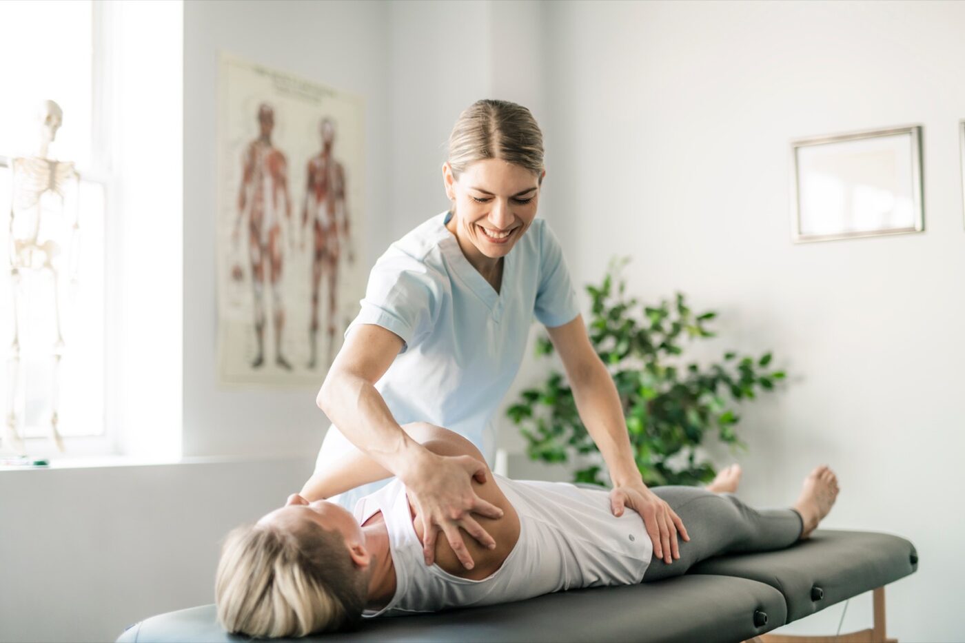 A Sports & Ortho therapist working with a post-mastectomy patient in a private treatment room