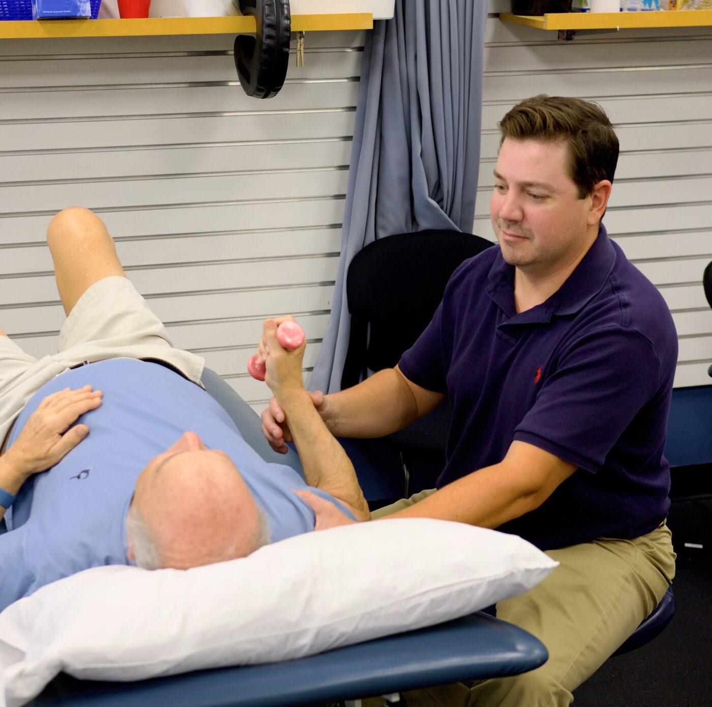 A Sports & Ortho therapist guiding a patient through post-surgical rehab