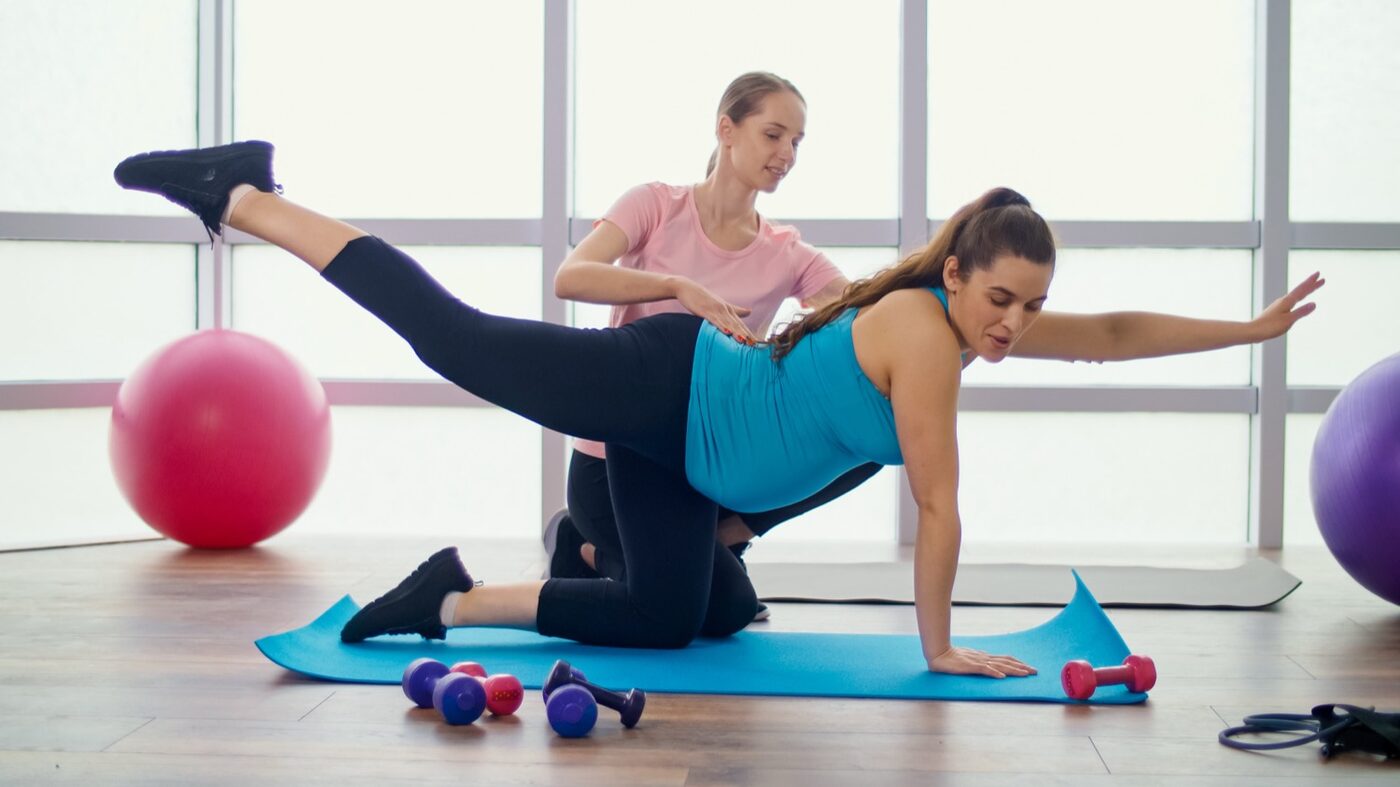 A Sports & Ortho therapist guiding an expecting mother through a prenatal exercise