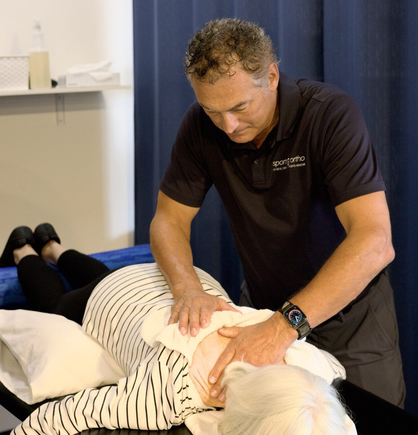 A Sports & Ortho therapist performing clinical soft-tissue massage on a patient