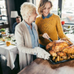 mother and daughter cooking thanksgiving turkey