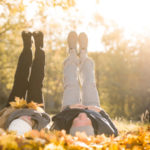 older couple laying in fall leaves