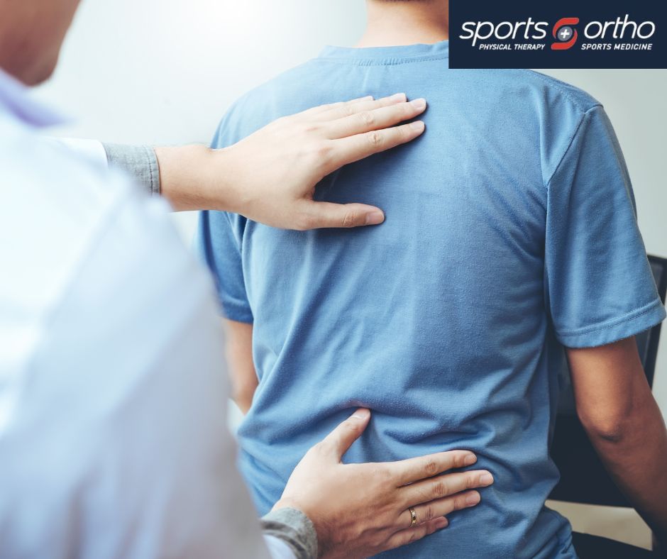 A doctor examining a man's back for any potential issues during a medical check-up.