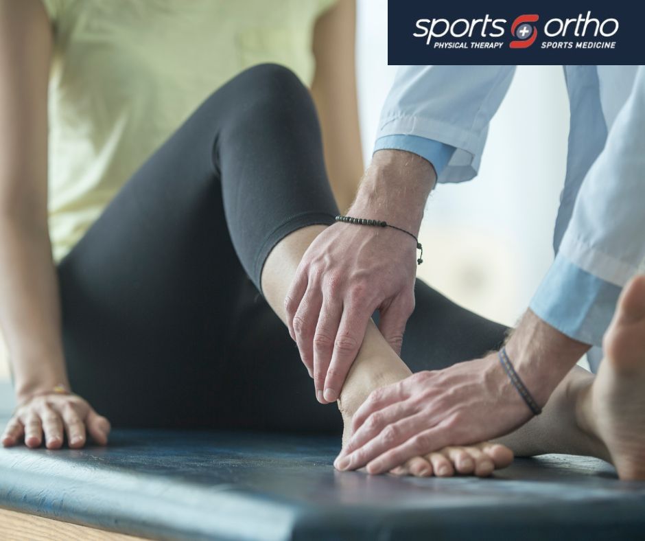 A sports orthopedic doctor examining a woman's foot during a medical consultation.